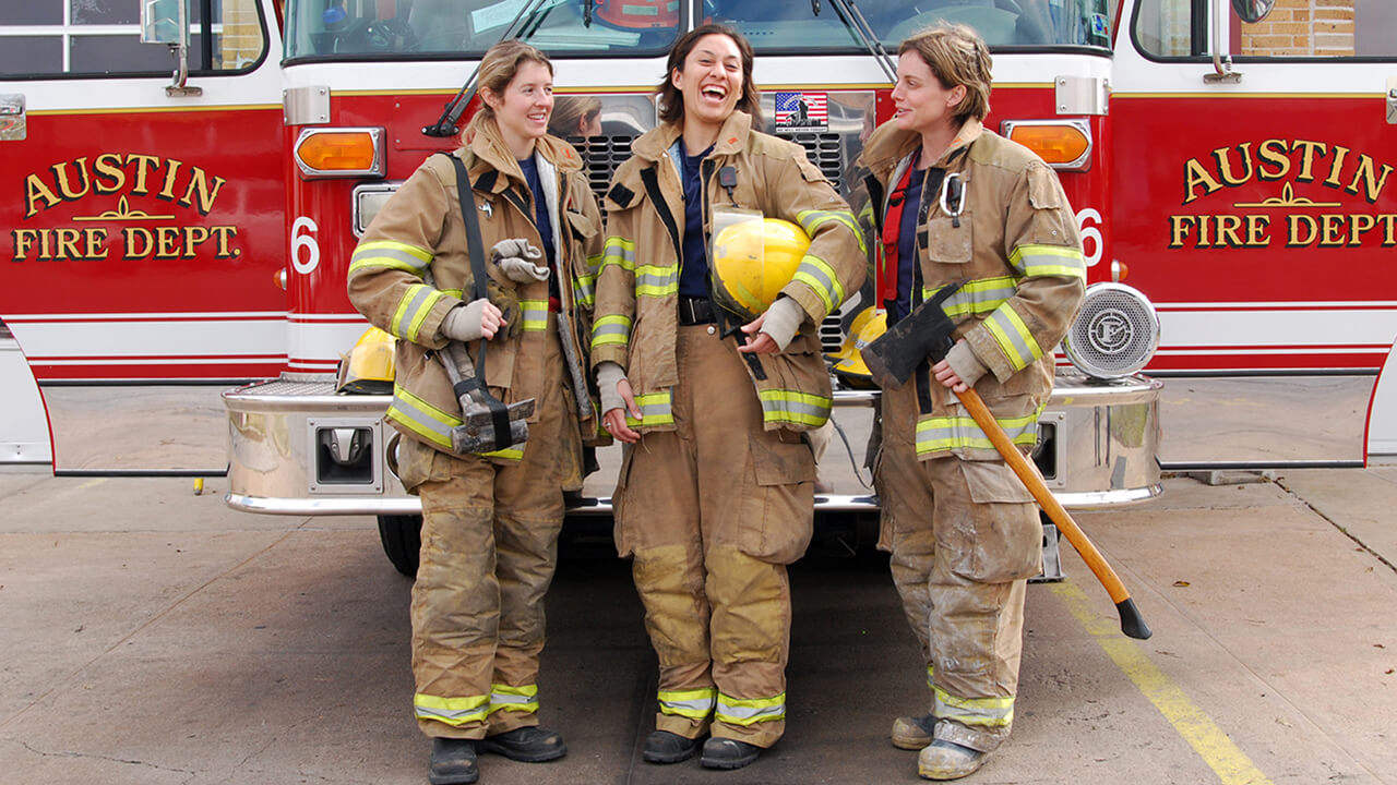 3 women firefighters in front of their rig