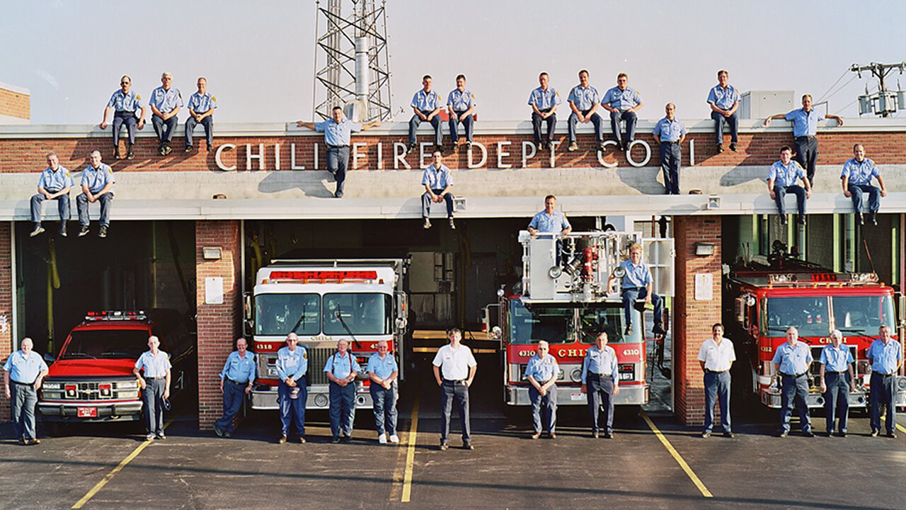 Fire department members above and in front of bay
