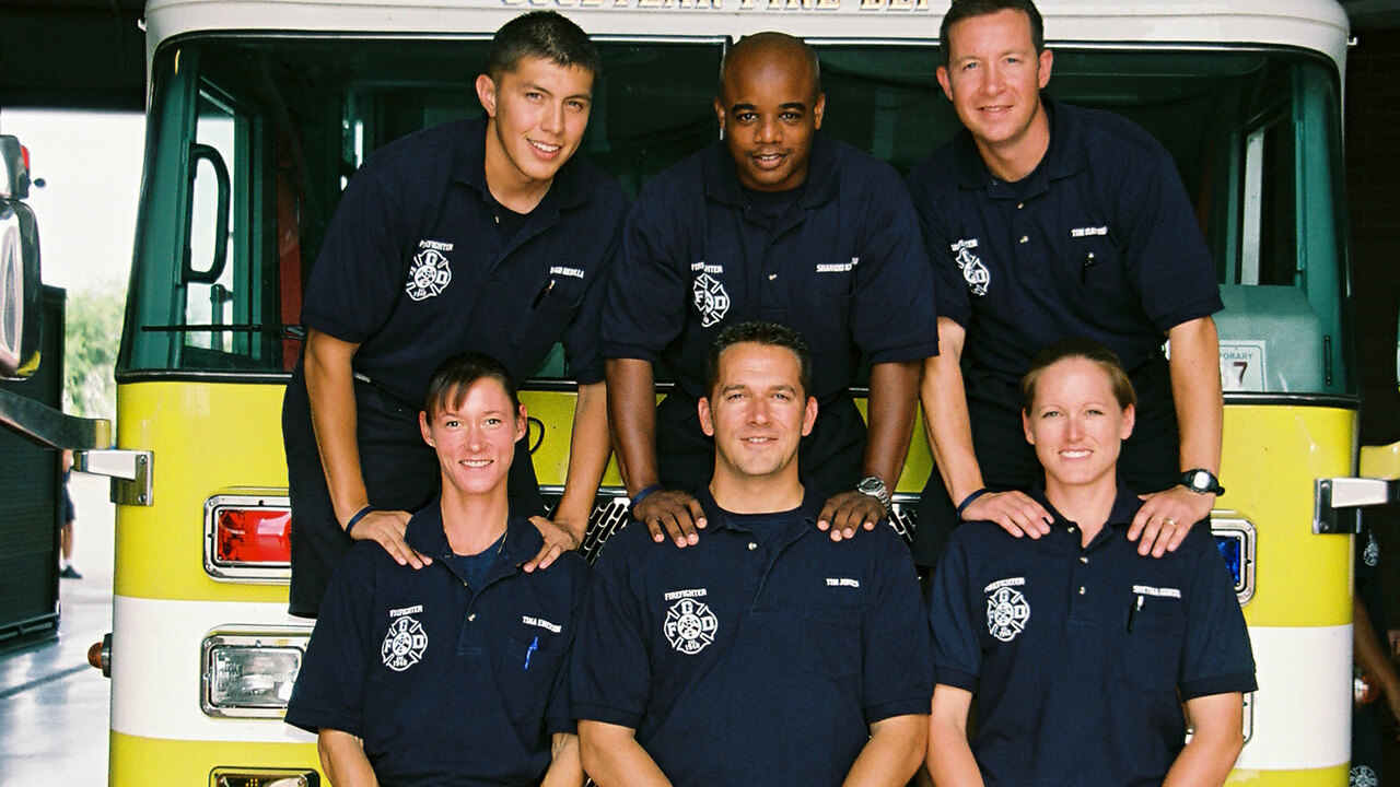 Crew posing on front of truck in bay